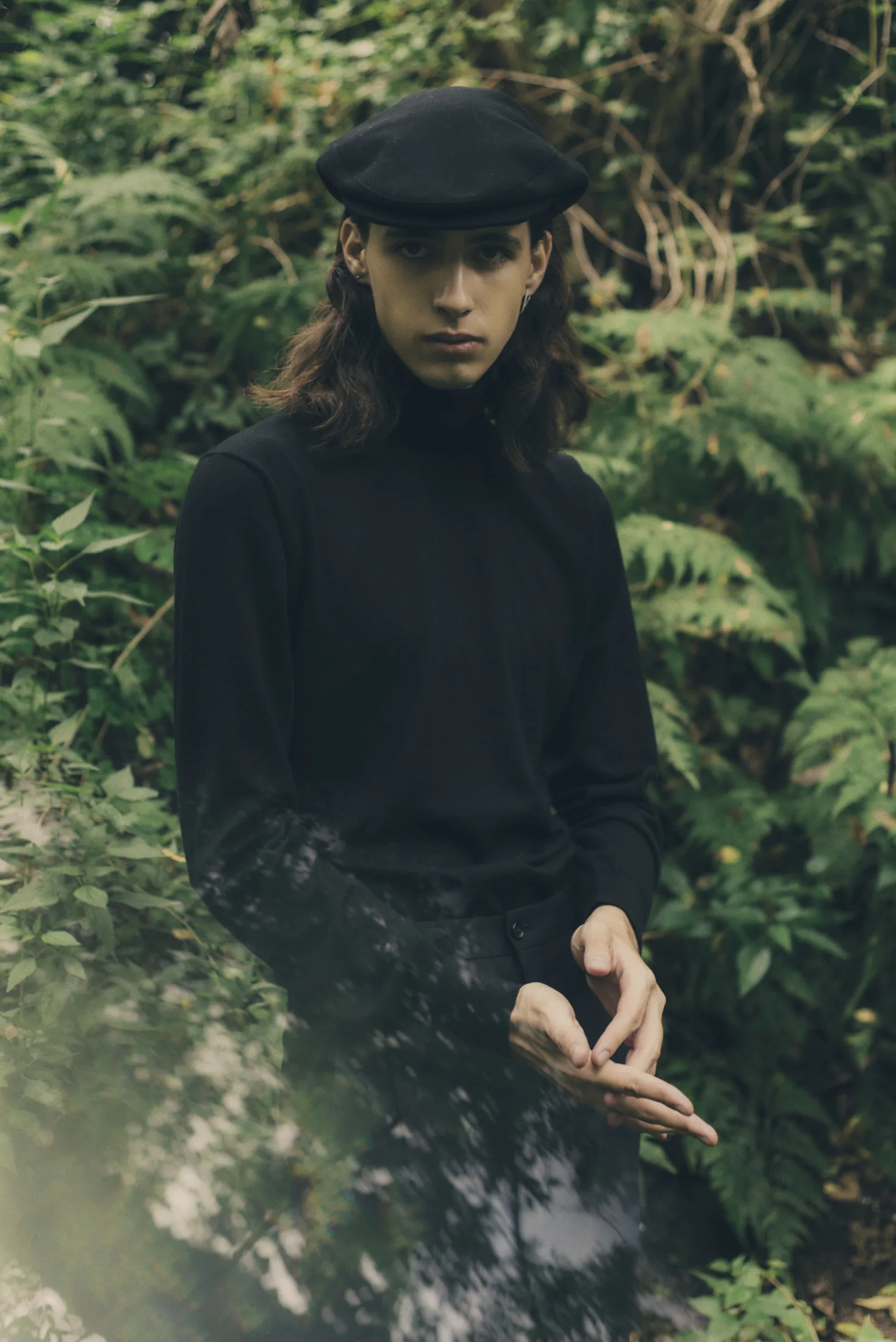 Fernando Icazbalceta in dark clothing in dense green foliage for GQ México